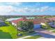 Breathtaking aerial view of a home near the lake, featuring tile roof, green lawn, and mature trees at 13145 Amerigo Ln, Venice, FL 34293