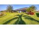 Lush backyard with a lake view, palm trees, and manicured landscaping at 13145 Amerigo Ln, Venice, FL 34293