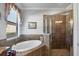 Inviting bathroom offers a soaking tub and a glass-enclosed shower for a spa-like experience at 13145 Amerigo Ln, Venice, FL 34293