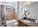 Cozy bathroom features a shower-tub combo and a granite vanity with coordinated fixtures at 13145 Amerigo Ln, Venice, FL 34293