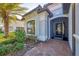 Elegant home entrance with decorative door, lush landscaping, brick pavers and large window at 13145 Amerigo Ln, Venice, FL 34293