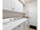 Functional laundry room with updated appliances, cabinetry, and a granite countertop at 13145 Amerigo Ln, Venice, FL 34293