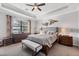 Comfortable main bedroom with decorative trey ceiling, neutral decor, and view of the backyard pond at 13145 Amerigo Ln, Venice, FL 34293