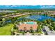 Stunning aerial view of a community pool, clubhouse, and serene lake surrounded by lush landscaping at 13719 Messina Loop # 101, Lakewood Ranch, FL 34211
