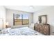 Neutral bedroom featuring a decorative dresser, a plush chair, and a bright window at 13719 Messina Loop # 101, Lakewood Ranch, FL 34211