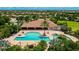 A stunning view of the community pool with shaded seating and lush landscaping at 13719 Messina Loop # 101, Lakewood Ranch, FL 34211