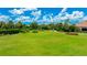 Expansive green space with lush lawn, walking paths, mature landscaping, and a tranquil pond at 13719 Messina Loop # 101, Lakewood Ranch, FL 34211