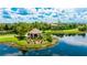 Picturesque gazebo by a tranquil lake, surrounded by lush greenery and mature trees at 13719 Messina Loop # 101, Lakewood Ranch, FL 34211
