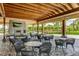 Covered outdoor seating area with comfortable chairs and tables, overlooking lush landscaping at 13719 Messina Loop # 101, Lakewood Ranch, FL 34211