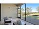 Enclosed patio with seating offering a view of community, green space, and mature trees at 13719 Messina Loop # 101, Lakewood Ranch, FL 34211