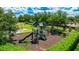 playground featuring slides and climbing structures nestled amid green grass and mature shade trees at 13719 Messina Loop # 101, Lakewood Ranch, FL 34211