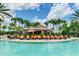 Resort-style pool with lounge chairs, umbrellas, and a Bahama Bar in a lush, tropical setting at 13719 Messina Loop # 101, Lakewood Ranch, FL 34211