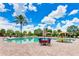 Beautiful pool with dining, lounge seating, and palm trees with a stunning blue sky at 13719 Messina Loop # 101, Lakewood Ranch, FL 34211