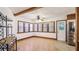 Bright dining room with beamed ceiling, hard wood floors, and adjacent kitchen with stainless steel refrigerator at 1406 5Th W St, Palmetto, FL 34221