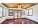 Bright sunroom with terra cotta tile, wood ceiling, and decorative double doors leading to the outside at 1406 5Th W St, Palmetto, FL 34221