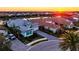 Beautiful waterfront community featuring a home with a tile roof and well-manicured landscaping at sunset at 15430 Blackmoor Ter, Lakewood Ranch, FL 34202