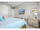 Bedroom featuring a TV on the wall, wicker nightstand, neutral paint, and coastal accents at 15430 Blackmoor Ter, Lakewood Ranch, FL 34202