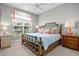 Coastal bedroom features a bamboo bed frame, bright pillows, ceiling fan, and natural light at 15430 Blackmoor Ter, Lakewood Ranch, FL 34202