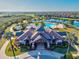 Aerial view showing a clubhouse in a lakefront community surrounded by palm trees at 15430 Blackmoor Ter, Lakewood Ranch, FL 34202
