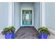 Inviting entryway showcases a decorative door and vibrant planters at 15430 Blackmoor Ter, Lakewood Ranch, FL 34202