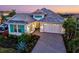 Charming single-Gathering home with turquoise shutters, a paver driveway, and a two-car garage at 15430 Blackmoor Ter, Lakewood Ranch, FL 34202