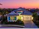 Beautiful single-Gathering home featuring turquoise shutters and a two-car garage at sunset at 15430 Blackmoor Ter, Lakewood Ranch, FL 34202