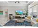 Comfortable living room with large windows, stylish furniture, and a patterned blue rug at 15430 Blackmoor Ter, Lakewood Ranch, FL 34202
