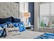 The main bedroom features an accent wall, shutters, and a white comforter with blue patterned pillows at 15430 Blackmoor Ter, Lakewood Ranch, FL 34202