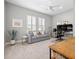 Home office with a striped couch, a large desk, neutral walls and bright windows at 15430 Blackmoor Ter, Lakewood Ranch, FL 34202