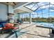 Open patio boasts a built-in grill area, a dining table, and a pool with views of the lake at 15430 Blackmoor Ter, Lakewood Ranch, FL 34202