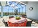 Screened patio offers a view of the pool and pond, perfect for outdoor dining and relaxation at 15430 Blackmoor Ter, Lakewood Ranch, FL 34202