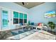 Comfortable screened patio with a ceiling fan, TV, stylish seating, and a blue accent wall at 15430 Blackmoor Ter, Lakewood Ranch, FL 34202