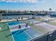 Aerial view of active pickleball courts with players, benches, and viewing area under a blue sky at 15430 Blackmoor Ter, Lakewood Ranch, FL 34202