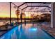Screened pool with a spa and lake views at sunset at 15430 Blackmoor Ter, Lakewood Ranch, FL 34202