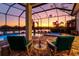An evening view of the screened pool and spa with a lake view at 15430 Blackmoor Ter, Lakewood Ranch, FL 34202