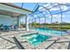 Screened-in pool and spa with a view of the lake, surrounded by comfortable seating and landscaping at 15430 Blackmoor Ter, Lakewood Ranch, FL 34202