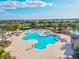 Aerial view showcases a large community pool with lounging areas and lush palm trees at 15430 Blackmoor Ter, Lakewood Ranch, FL 34202