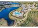 Aerial view of community clover shaped pool next to a lake with a paved walkway at 15430 Blackmoor Ter, Lakewood Ranch, FL 34202