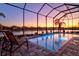 An evening view of the screened pool with a waterfront view at 15430 Blackmoor Ter, Lakewood Ranch, FL 34202