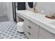 Chic bathroom features a patterned tile floor, gray vanity with white countertop and stool at 16419 Kendleshire Ter, Lakewood Ranch, FL 34202