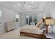 Relaxing bedroom featuring tray ceiling and a sliding glass door to a screen enclosed hot tub patio at 16419 Kendleshire Ter, Lakewood Ranch, FL 34202