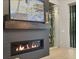 A linear fireplace with a floating mantel, TV above, and a clear glass wine cellar at 16419 Kendleshire Ter, Lakewood Ranch, FL 34202