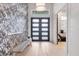 Foyer featuring a statement wall, bench seating, and modern front door at 16419 Kendleshire Ter, Lakewood Ranch, FL 34202