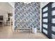 Foyer featuring a statement wall, bench seating, and modern front door at 16419 Kendleshire Ter, Lakewood Ranch, FL 34202