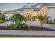 Stunning home exterior featuring lush landscaping, a paved driveway, and an inviting entrance at 16419 Kendleshire Ter, Lakewood Ranch, FL 34202