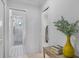 Hallway with open doorways leading to a bathroom and other rooms, with stylish console table with books and plants at 16419 Kendleshire Ter, Lakewood Ranch, FL 34202