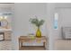 Hallway featuring a wooden console table adorned with a vase and view into a bathroom at 16419 Kendleshire Ter, Lakewood Ranch, FL 34202