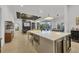 Open-concept kitchen featuring a spacious island with seating and stainless steel appliances, connecting to living and dining areas at 16419 Kendleshire Ter, Lakewood Ranch, FL 34202