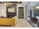 Cozy living room with a fireplace, adjacent wine cellar, and access to the covered outdoor space at 16419 Kendleshire Ter, Lakewood Ranch, FL 34202
