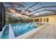 An outdoor pool sparkles under a screened enclosure, reflecting the sky and surrounding landscaping at 16419 Kendleshire Ter, Lakewood Ranch, FL 34202